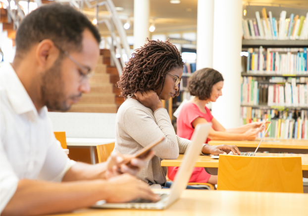 Woman working on laptop in a library